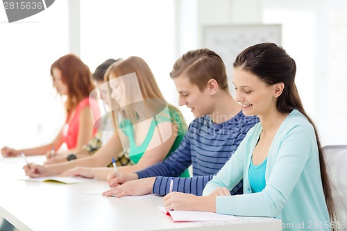 Image of smiling students with textbooks at school