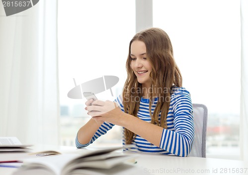 Image of smiling student girl with smartphone and books