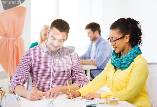 Image of smiling designers drawing sketches in office