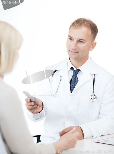 Image of doctor giving tablets to patient in hospital