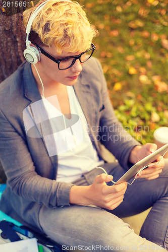 Image of smiling male student in eyeglasses with tablet pc
