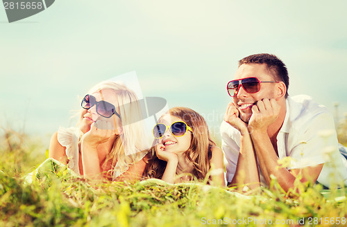 Image of happy family with blue sky and green grass