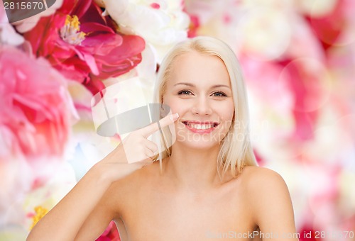 Image of smiling young woman pointing to her nose