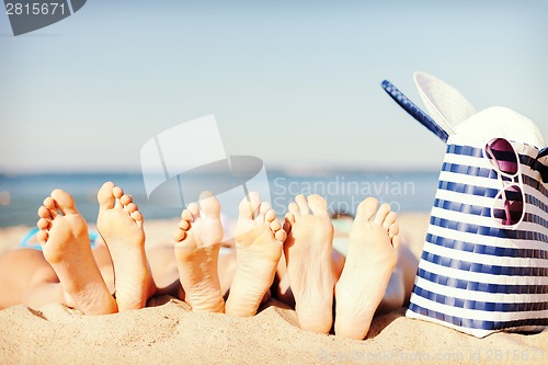 Image of three women lying on the beach