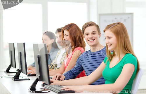 Image of smiling student with computer studying at school