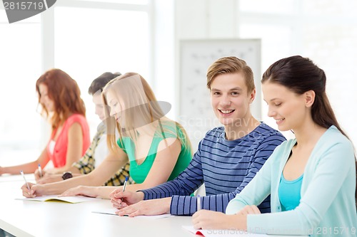 Image of smiling students with textbooks at school