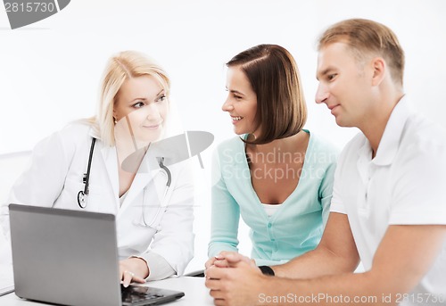 Image of doctor with patients looking at laptop