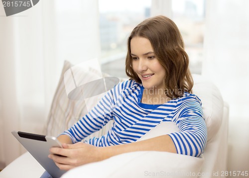 Image of smiling teenage girl with tablet pc at home