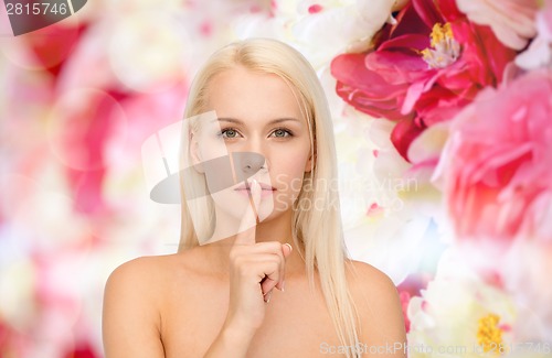 Image of calm young woman with finger on lips