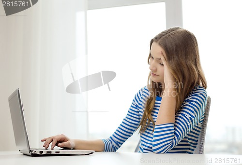 Image of upset teenage gitl with laptop computer at home