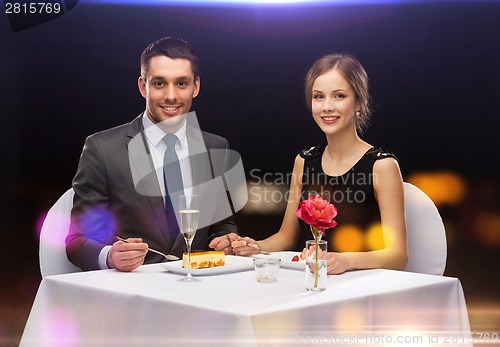 Image of smiling couple eating dessert at restaurant