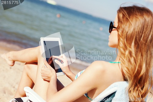 Image of girl looking at tablet pc on the beach