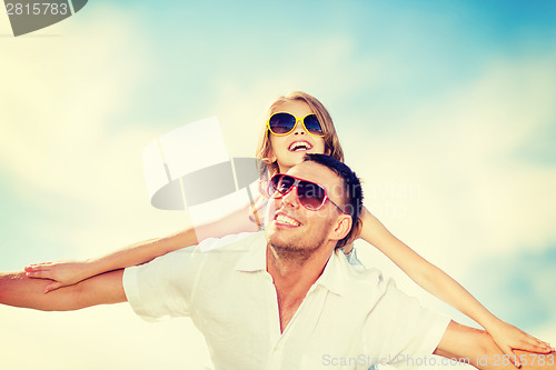 Image of happy father and child in sunglasses over blue sky