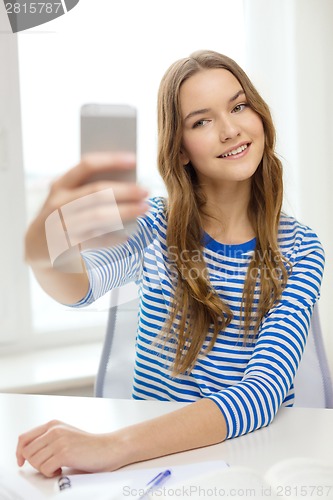 Image of smiling student girl with smartphone and books