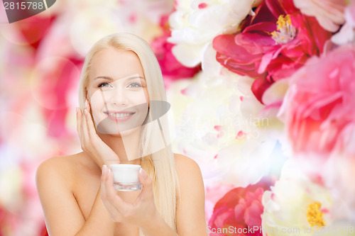 Image of woman applying cream on her skin