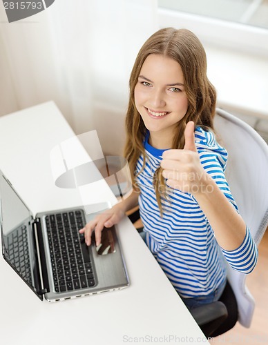 Image of smiling teenage gitl with laptop computer at home