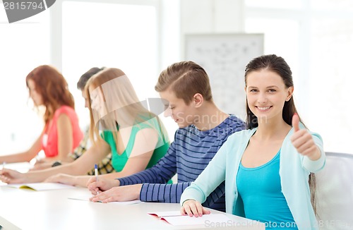 Image of smiling students with textbooks at school