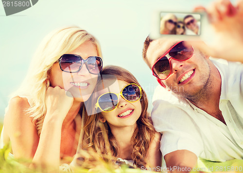 Image of happy family with camera taking picture
