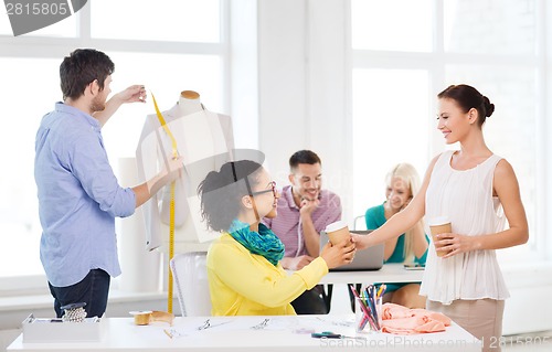 Image of smiling fashion designers working in office