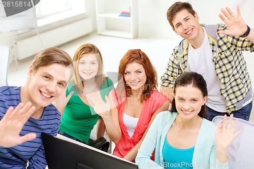 Image of group of smiling students waving hands at school
