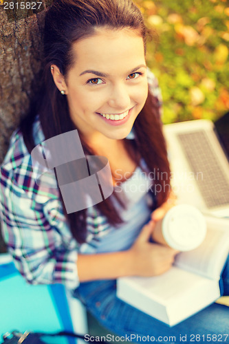 Image of teenager reading book with take away coffee