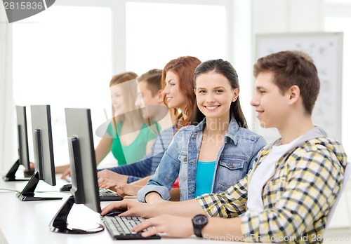 Image of smiling student with computer studying at school