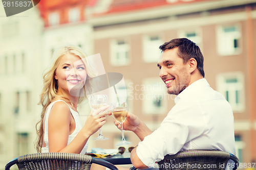 Image of smiling couple drinking wine in cafe