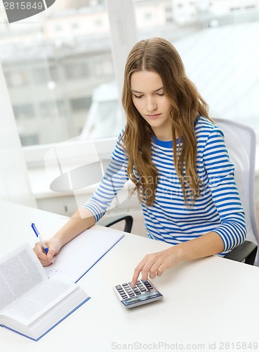 Image of student girl with book, calculator and notebook