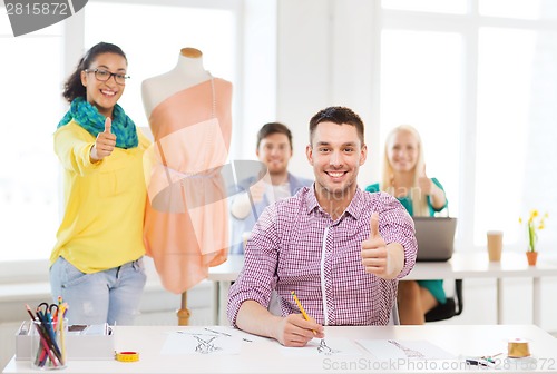 Image of smiling fashion designers working in office