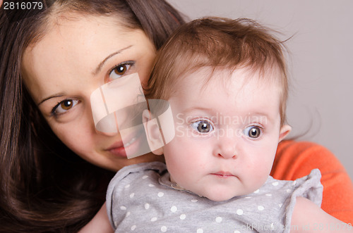 Image of Young happy mother kissing her daughter