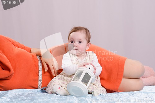 Image of Girl with a nightlight is sitting next to her mother