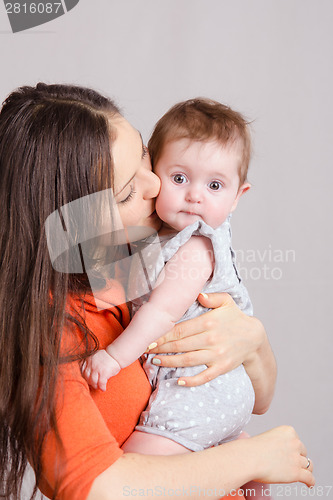 Image of Young mother kissing her daughter