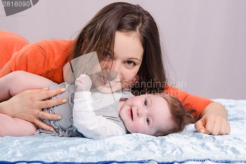Image of Mom and seven-month baby lying on couch fun