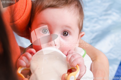 Image of Six-month girl drinks milk from a bottle