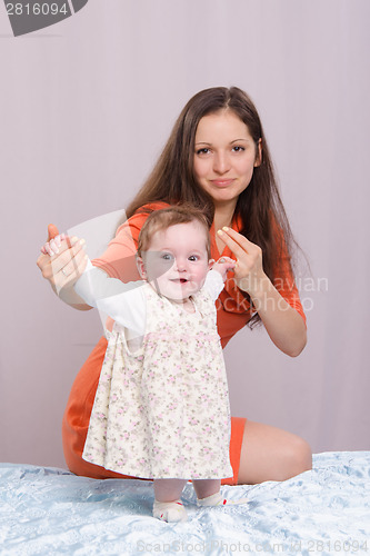 Image of Mom with a six-month daughter on the bed