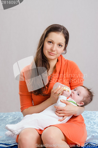 Image of Mum feeds from a bottle daughter