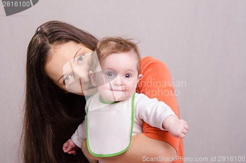 Image of Young happy mother kissing her daughter