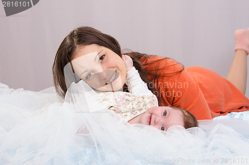 Image of Mom and daughter having fun six-month lay on bed