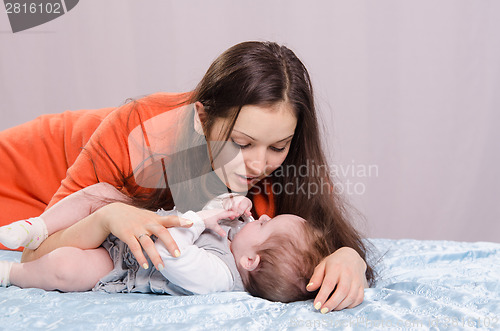 Image of Mum and daughter lie on a six-month couch