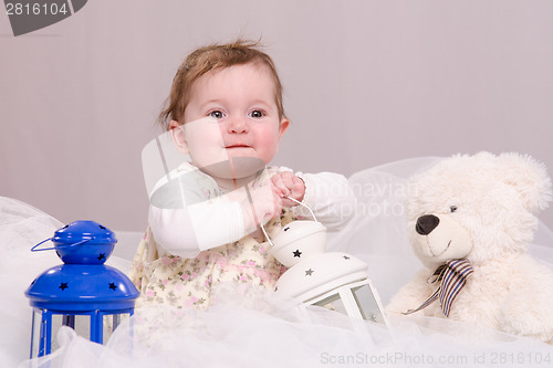 Image of Six-month baby girl playing with toys
