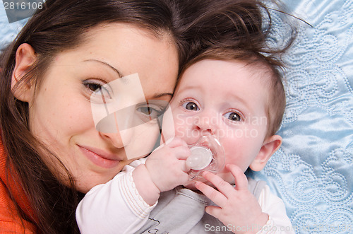 Image of Portrait of mother and baby lying in a crib