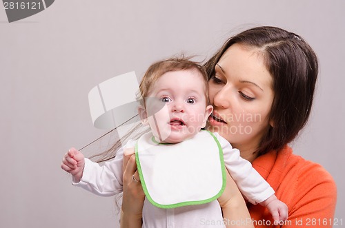 Image of Six-month baby girl in bib tear your hair mom