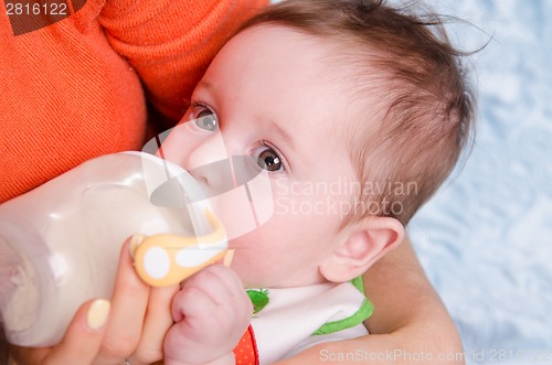 Image of Six month old baby drinking milk from a bottle