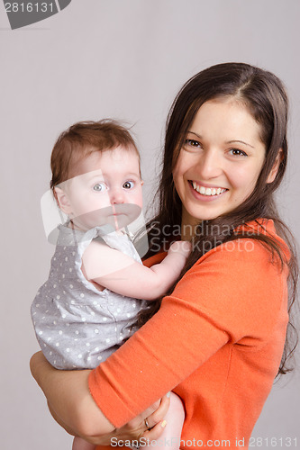 Image of Young mother hugging her daughter