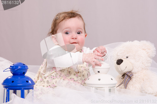 Image of Six-month baby girl playing with toys on couch