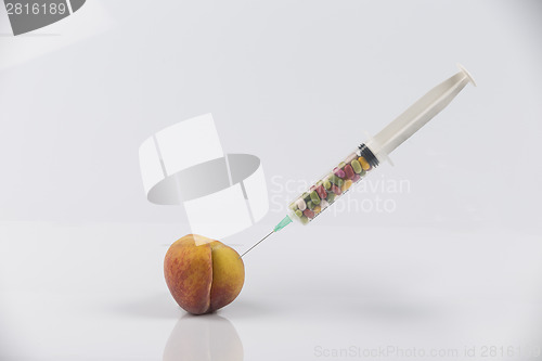 Image of Peach and syringe with pills