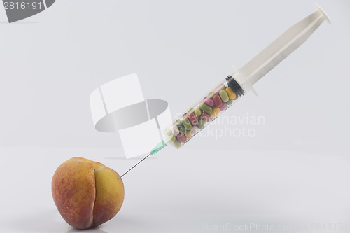 Image of Peach and syringe with pills