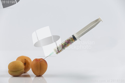 Image of Apricots and syringe with pills