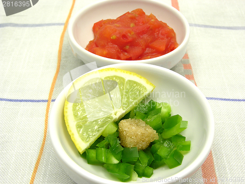 Image of Little bowls of chinaware with tomatodip and green pepperdip