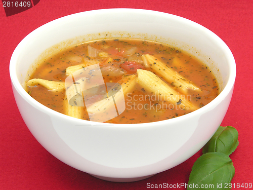 Image of Noodle soup with tomatoes and herbs on red